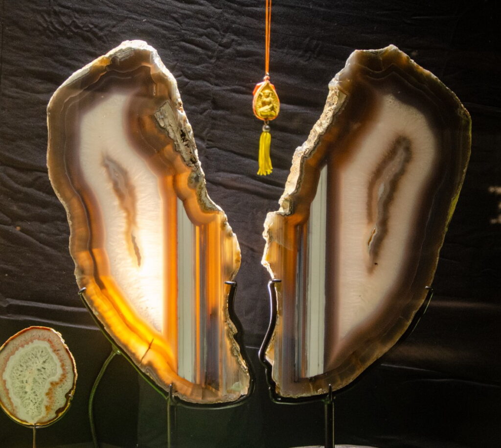 Two polished agate halves glowing under backlight on display stands