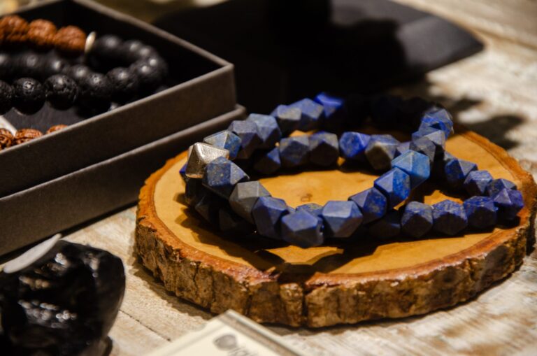 Bracelet of faceted blue stones on a wooden slice