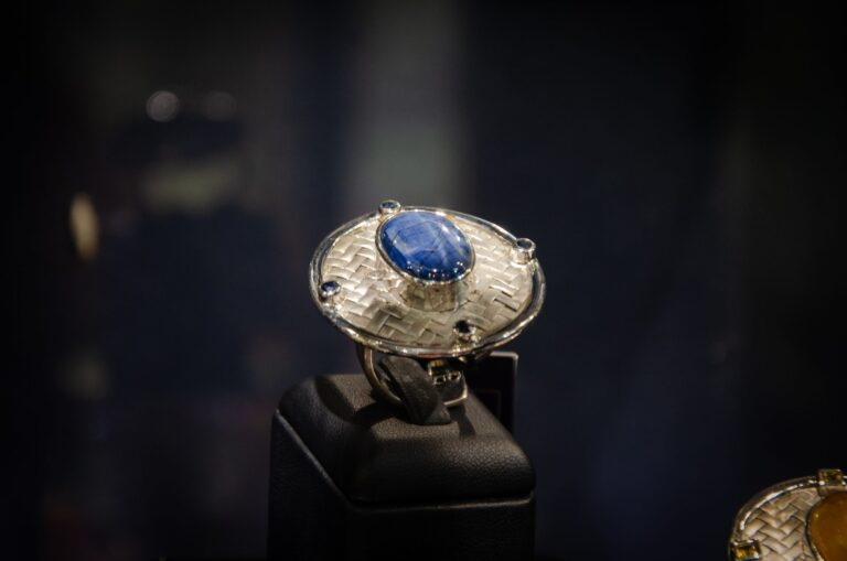 Silver ring with a blue cabochon stone on a black stand