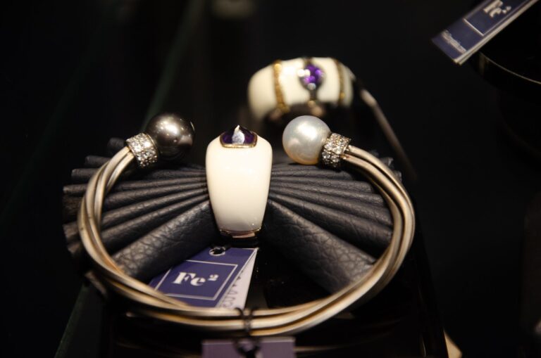 Silver bangle with a pearl detail on a black stand