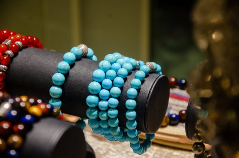 Blue and red bead bracelets stacked on a black stand
