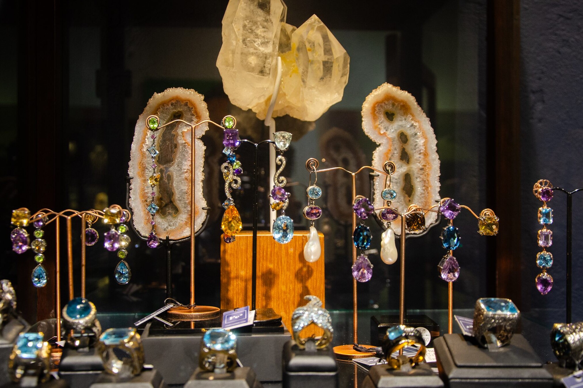 Gemstone drop earrings and rings on display stands