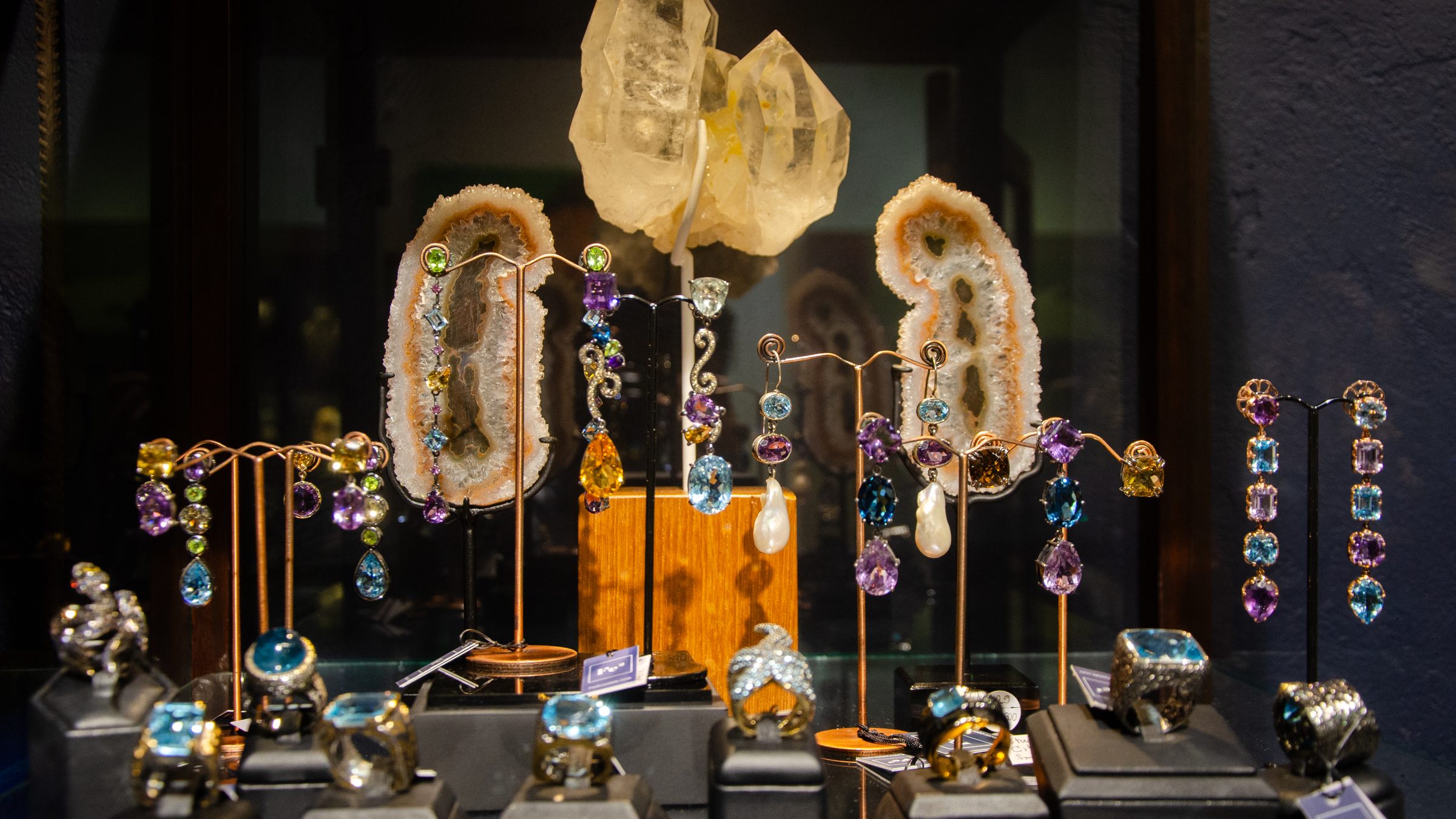 Gemstone drop earrings and rings on display stands