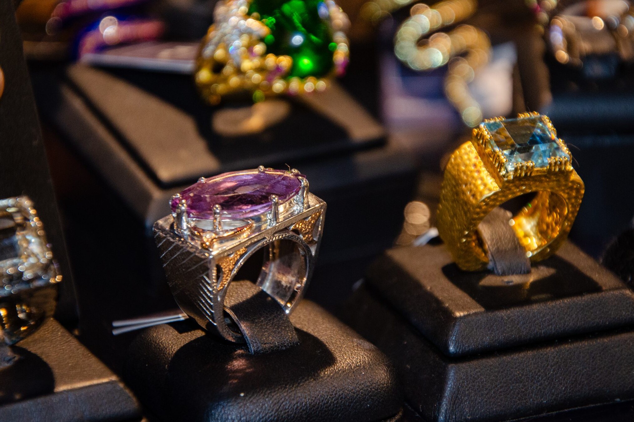 Bold rings with large purple and blue stones on display