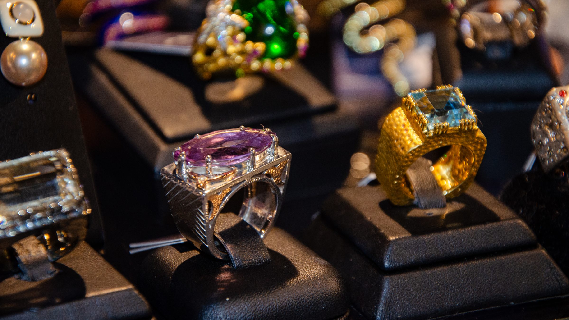 Bold rings with large purple and blue stones on display