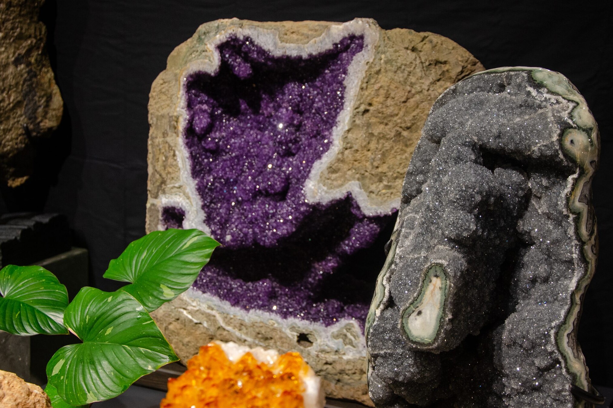Large amethyst geode beside a grey crystal geode