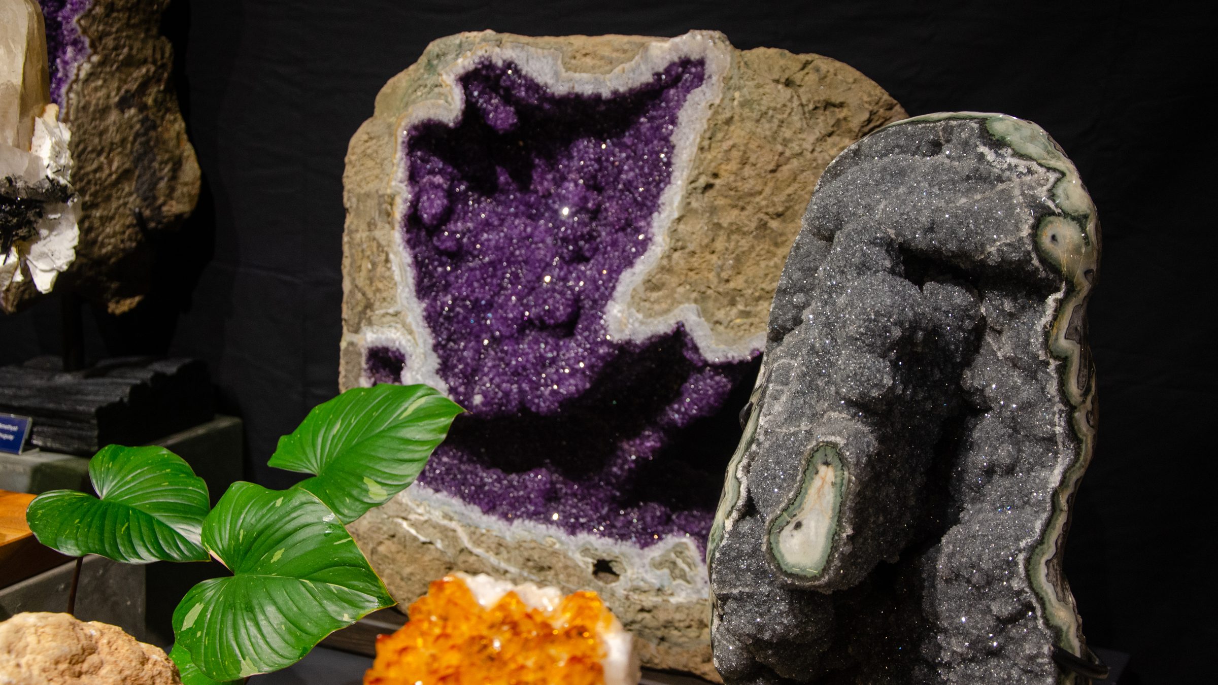 Large amethyst geode beside a grey crystal geode